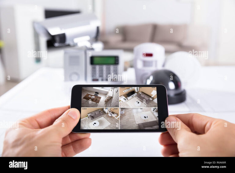 person-holding-mobile-phone-with-cctv-camera-footage-on-screen-R6A66R